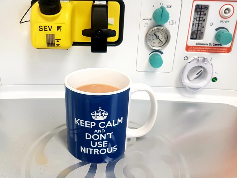 A mug of tea with a reminder about not using nitrous, sitting on an anaesthetic machine